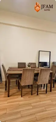 a dining room with a wooden table and chairs at JFam Suites, C1-5L 1BR , Up To 7 Pax in Biñan