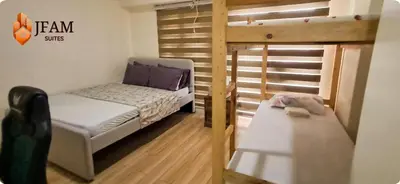 a room with two beds and a bunk bed at JFam Suites, C1-5L 1BR , Up To 7 Pax in Biñan
