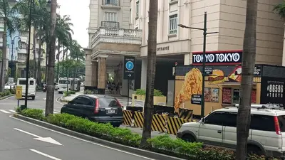 a street with cars parked in front of a restaurant at Condotels near and across Terminal3 Airport in Manila