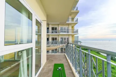 a balcony with a view of the ocean at Ocean View Condo with Infinity Pool, Gym, Spa - Next to Okada, Solaire & MOA in Manila