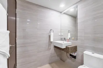 a bathroom with a sink and a toilet at Ocean View Condo with Infinity Pool, Gym, Spa - Next to Okada, Solaire & MOA in Manila