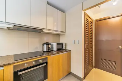 a kitchen with white cabinets and a counter top at Ocean View Condo with Infinity Pool, Gym, Spa - Next to Okada, Solaire & MOA in Manila