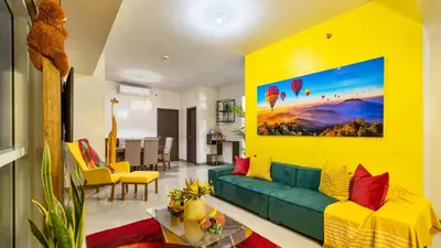 a living room with a green couch and a yellow wall at Ocean View Condo with Infinity Pool, Gym, Spa - Next to Okada, Solaire & MOA in Manila