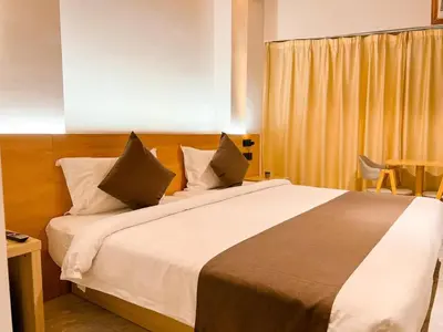a bedroom with a large bed and a table at Terra Hotel Kawit in Kawit