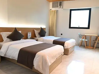 a hotel room with two beds and a window at Terra Hotel Kawit in Kawit