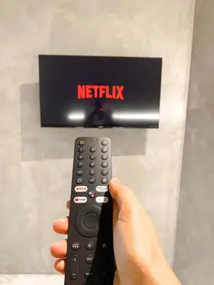 a person holding a remote control in front of a television at Terra Hotel Kawit in Kawit