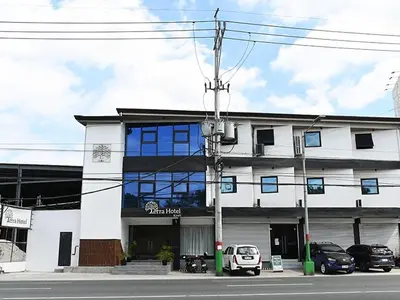 a white building with cars parked in front of it at Terra Hotel Kawit in Kawit