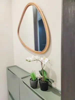 a mirror and two plants on a glass dresser at LUXESTAYSMNL STYLISH FAMILY 2BR SUITE POOLGYM 400MBPS WIFI NETFLX Amazing City View in Manila
