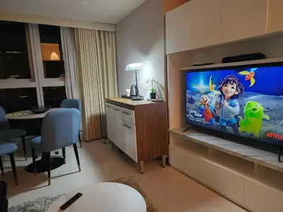 a hotel room with a tv in a room at LUXESTAYSMNL STYLISH FAMILY 2BR SUITE POOLGYM 400MBPS WIFI NETFLX Amazing City View in Manila
