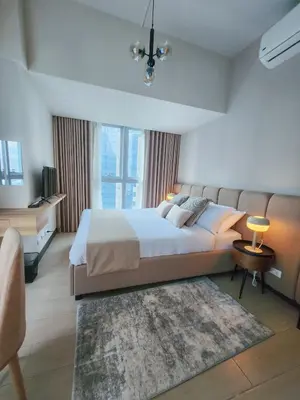 a large bedroom with a large bed and a rug at LUXESTAYSMNL STYLISH FAMILY 2BR SUITE POOLGYM 400MBPS WIFI NETFLX Amazing City View in Manila