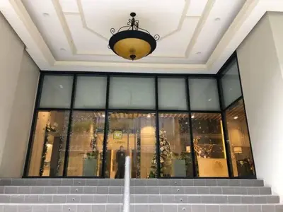 a building with a chandelier and stairs in front at LUXESTAYSMNL STYLISH FAMILY 2BR SUITE POOLGYM 400MBPS WIFI NETFLX Amazing City View in Manila