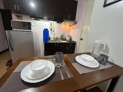 a kitchen with a table with white plates on it at Solstay in Manila