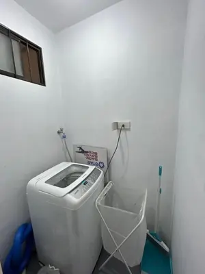 a bathroom with a washing machine in a room at Solstay in Manila