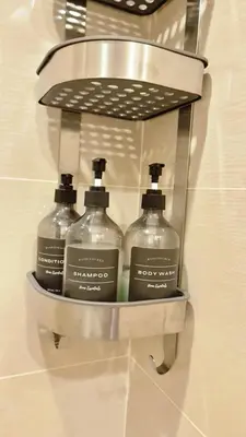 a shelf with three bottles of soap in a bathroom at LUXESTAYSMNL Parisian Charm 1BR Suite Pool Gym 400MBPS WiFi Netflix Amazing City View in Manila