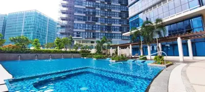 a large swimming pool in front of a building at LUXESTAYSMNL Parisian Charm 1BR Suite Pool Gym 400MBPS WiFi Netflix Amazing City View in Manila