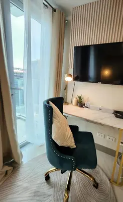 a chair with a pillow in a room with a desk at LUXESTAYSMNL Parisian Charm 1BR Suite Pool Gym 400MBPS WiFi Netflix Amazing City View in Manila
