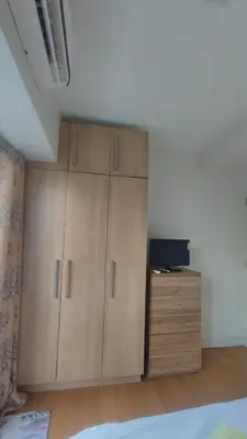 a bedroom with wooden cabinets and a tv on a dresser at Aveline Suites, Garden City view, 2br, amenities in Manila
