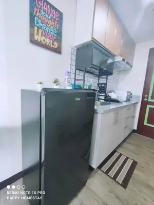 a kitchen with a black refrigerator in a room at Happy Homestay at Fullerton Suites Condo near Nuvali and Tagaytay in Silang