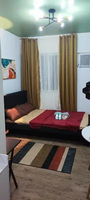 a large bed in a room with a window at Happy Homestay at Fullerton Suites Condo near Nuvali and Tagaytay in Silang