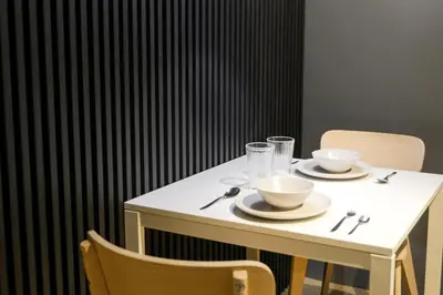 a white table with two cups and bowls on it at Siesta Spaces Adela in Manila