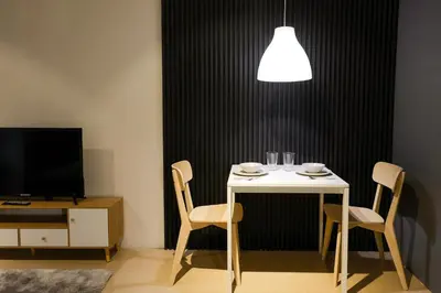 a table with two chairs and a white table and a tv at Siesta Spaces Adela in Manila