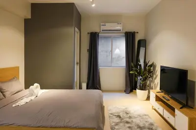a bedroom with a bed and a flat screen tv at Siesta Spaces Adela in Manila