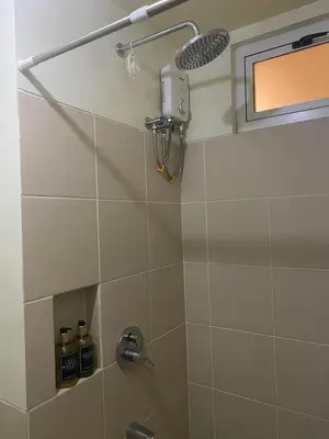 a bathroom with a shower with a shower head at Brixton place near bgc in Manila