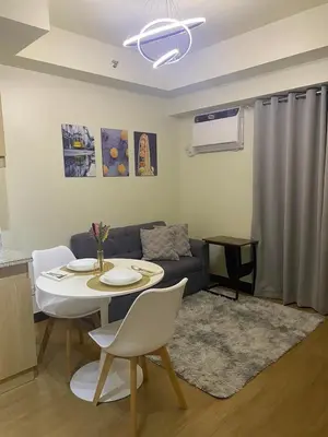 a living room with a table and a couch at Brixton place near bgc in Manila