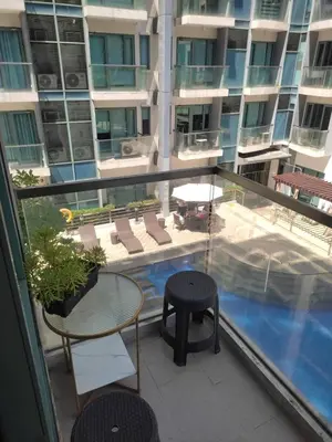 a balcony with a table and chairs and a pool at LDN Studio Unit Two Palm Tree in Manila