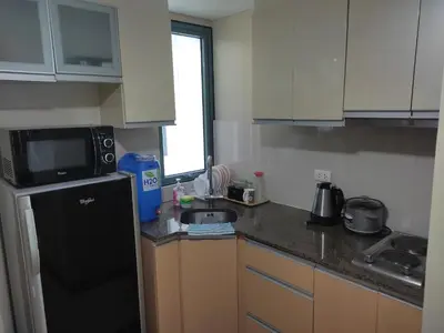 a kitchen with a black refrigerator and a sink at LDN Studio Unit Two Palm Tree in Manila
