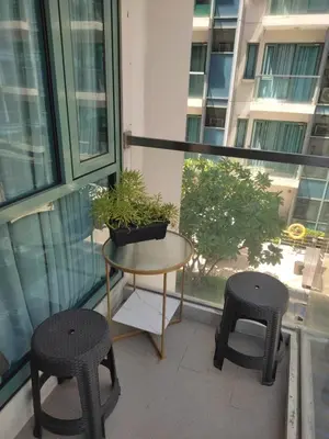 a balcony with a table and two stools at LDN Studio Unit Two Palm Tree in Manila