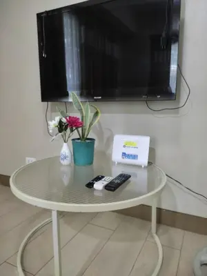 a table with a tv and two remote controls on it at LDN Studio Unit Two Palm Tree in Manila