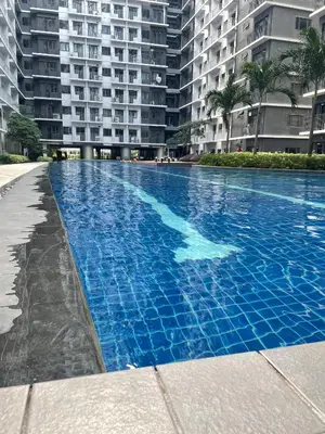 a large blue swimming pool in front of a building at Molly Shore Getaway Unit 1276 in Manila