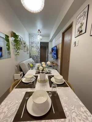a dining room with a table with plates on it at Molly Shore Getaway Unit 1276 in Manila