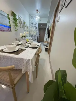 a dining room with a white table and chairs at Molly Shore Getaway Unit 1276 in Manila
