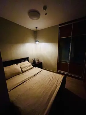 a bedroom with a bed and a window at Cozy 1BR with BGC View Gym and Pool Included in Manila