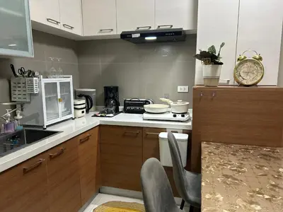 a kitchen with a sink and a counter top at Cozy 1BR with BGC View Gym and Pool Included in Manila
