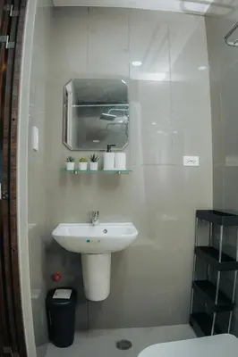 a white bathroom with a sink and a mirror at The House of Five - Brand New Hotel Style Condo in Manila