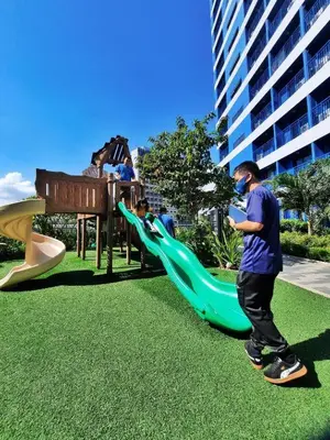 a man playing on a slide in a playground at The House of Five - Brand New Hotel Style Condo in Manila