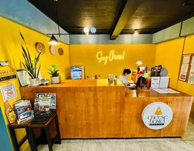a woman sitting at the counter of a restaurant at Cheese Hostel Manila in Manila