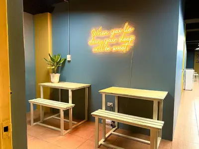 two benches next to a wall with a neon sign at Cheese Hostel Manila in Manila