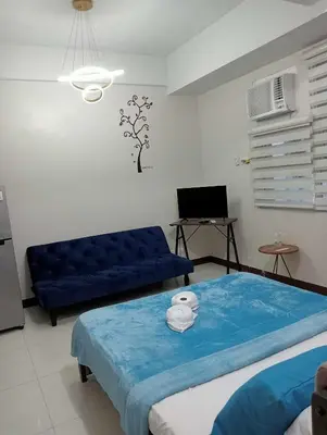 a living room with a blue bed and a couch at Newport 101 - East Wing in Manila