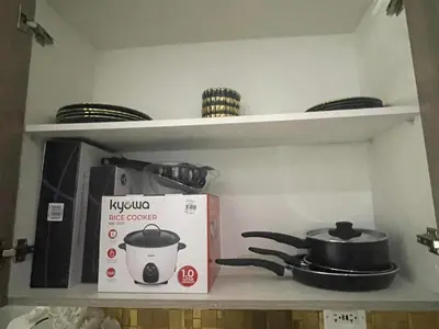 a kitchen shelf with a kivo stove and a box at Casa Jezhuel at Fame Residences in Manila