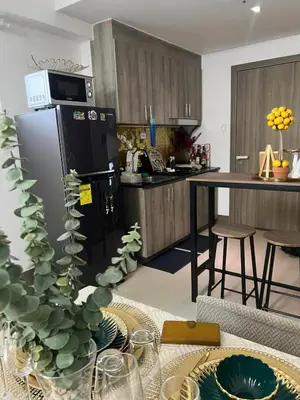 a kitchen with a stainless steel refrigerator and a table at Casa Jezhuel at Fame Residences in Manila