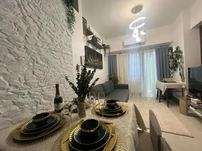 a dining room with a table and a stone wall at Casa Jezhuel at Fame Residences in Manila
