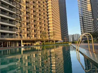 a pool in the middle of a city with tall buildings at Casa Jezhuel at Fame Residences in Manila