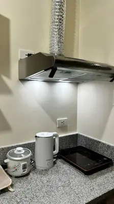 a kitchen counter with a coffee pot and a toaster at Cozy Studio Condo Unit at Fullerton Suites in Silang