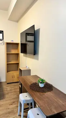 a room with a wooden table and two stools at Cozy Studio Condo Unit at Fullerton Suites in Silang