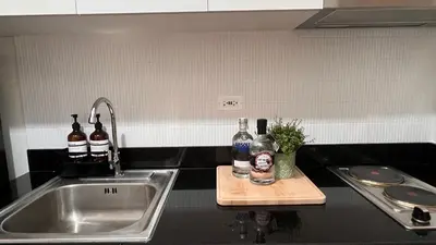 a kitchen sink with bottles of alcohol on a cutting board at Lemmon's Casita in Manila