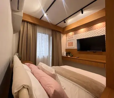 a hotel room with a bed and a flat screen tv at Lemmon's Casita in Manila